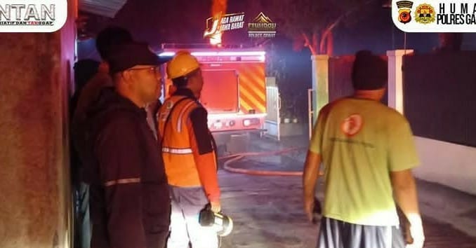 Petugas pemadam kebakaran bersama personel Polsek Cilawu memadamkan api yang menghanguskan tiga rumah kontrakan di Kampung Pasangrahan, Kecamatan Cilawu, Kabupaten Garut. (Sumber: Polres Garut)