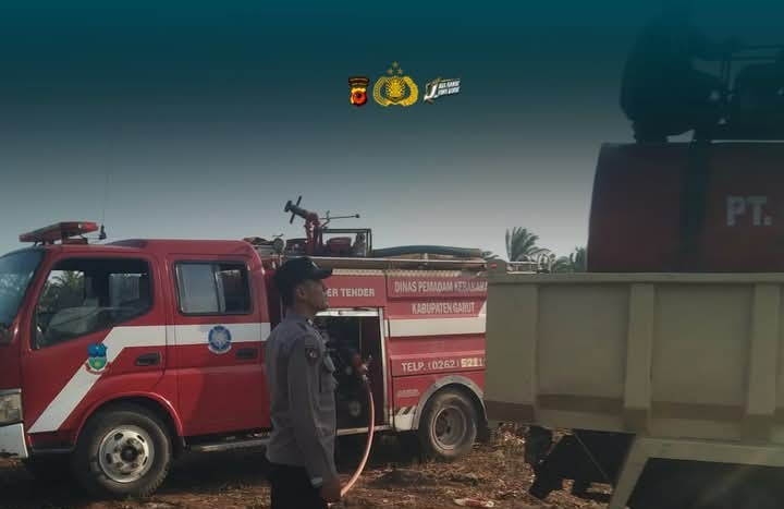 Petugas memadamkan kebakaran lahan perkebunan warga di Desa Cigadog, Kecamatan Cikelet, Garut. (Sember : Polres Garut)